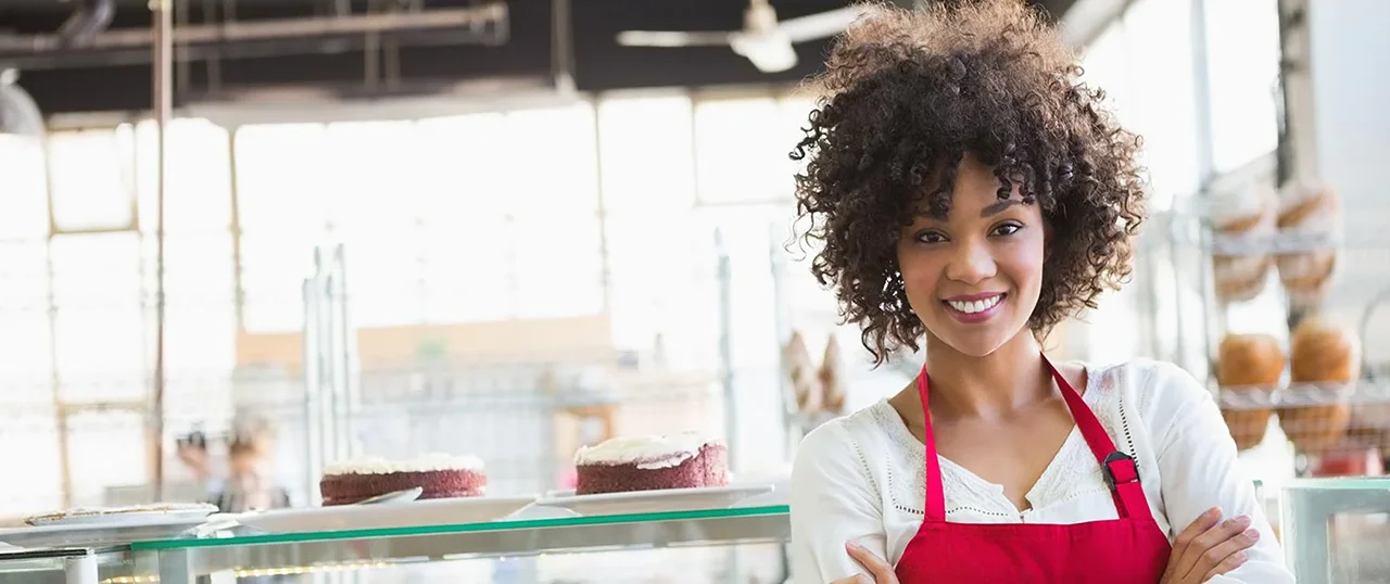 Female African American waitress in front of bakery case